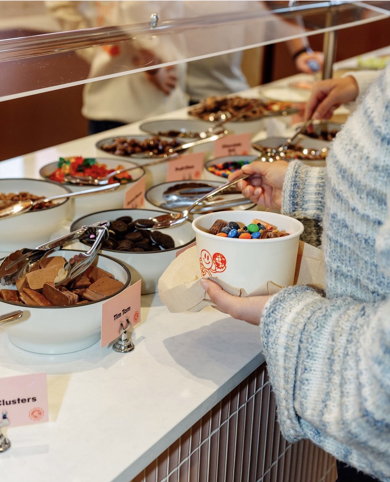 Customer adding toppings to a Yo World bowl